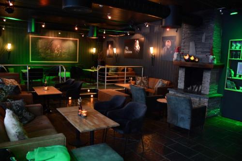 a restaurant with green lighting and tables and a fireplace at Radisson Blu Resort, Beitostølen in Beitostøl