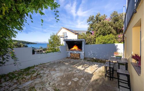 a backyard with a fireplace and a view of the water at 1 Bedroom Nice Apartment In Necujam in Nečujam