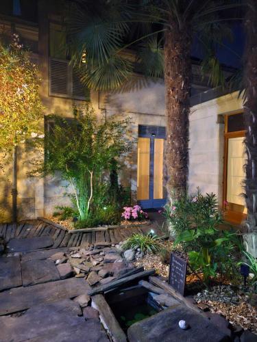 une maison avec un palmier en face d'une cour dans l'établissement Les Pénates de Loire, à Ancenis