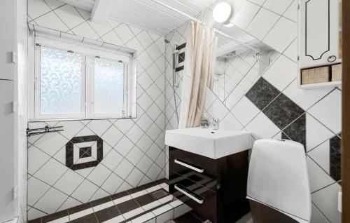 a white bathroom with a sink and a window at 3 Bedroom Cozy Home In Hadsten in Hadsten Stationsby