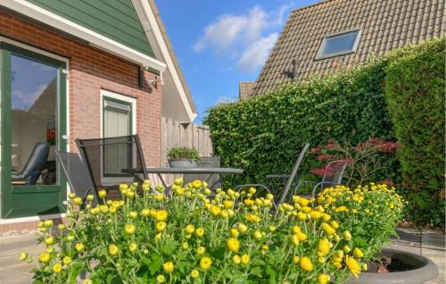 a garden with yellow flowers in front of a house at Pet Friendly Home In Opperdoes in Opperdoes