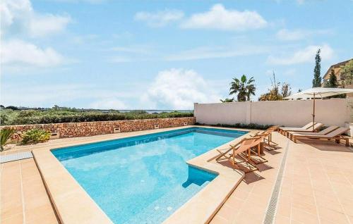 a swimming pool with two chairs and an umbrella at Casa Vistamar in S'Estanyol de Migjorn