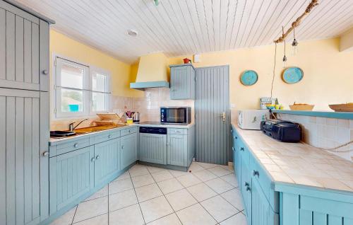 une cuisine avec des armoires bleues et un comptoir dans l'établissement 3 Bedroom Nice Home In Barbatre, à Barbâtre