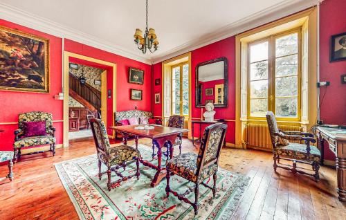une salle à manger avec des murs rouges, une table et des chaises dans l'établissement Maison Saint-Lyphard, à Saint-Lyphard