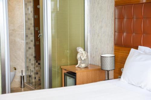 a bedroom with a bed and a statue on a table at The Hera Platinum Hotel in Istanbul