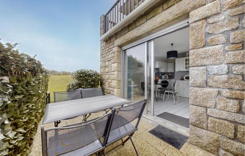 un bâtiment en pierre avec une table et des chaises sur une terrasse dans l'établissement 1 Bedroom Nice Apartment In Guidel, à Guidel