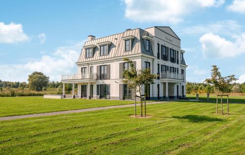 a large white house on a grassy field at Awesome Apartment In Kamperland in Kamperland