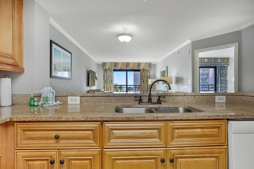 a kitchen counter with a sink and a mirror at Seas the View at Ocean Reef Resort #320 in Myrtle Beach