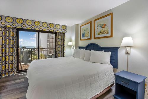 a bedroom with a large bed and a balcony at Seas the View at Ocean Reef Resort #320 in Myrtle Beach