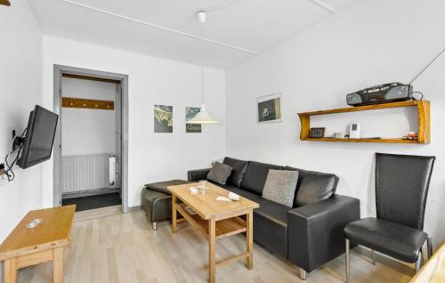 a living room with a black couch and a table at Gorgeous Apartment In Svaneke With Wifi in Svaneke
