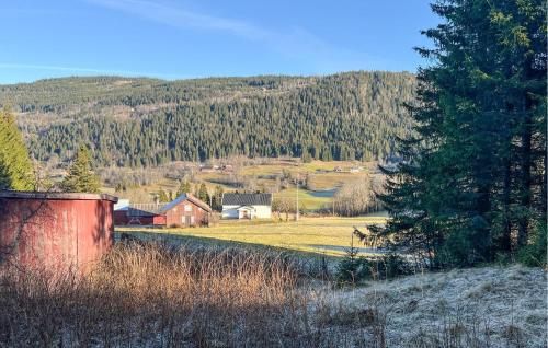 Blick auf ein Feld mit einem Haus und Bäumen in der Unterkunft Beautiful Home In Vestre Gausdal in Vestre Gausdal