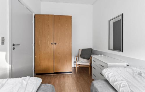 a bedroom with a closet and a dresser with a mirror at Nice Apartment In Nexø With Wifi in Neksø