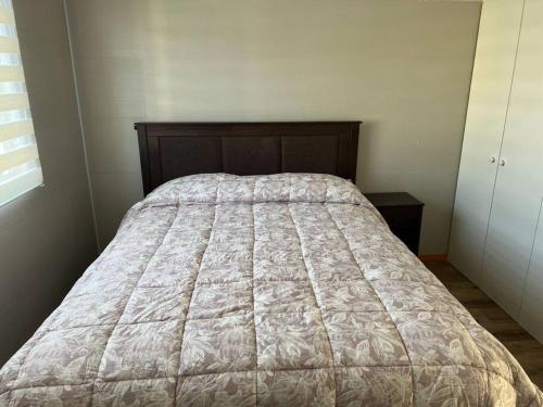 a bed in a bedroom with a bedspread on it at Arriendo Casa dos pisos por dia in Puerto Montt