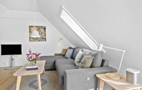 a living room with a couch and a tv at Awesome Apartment In Svaneke in Svaneke