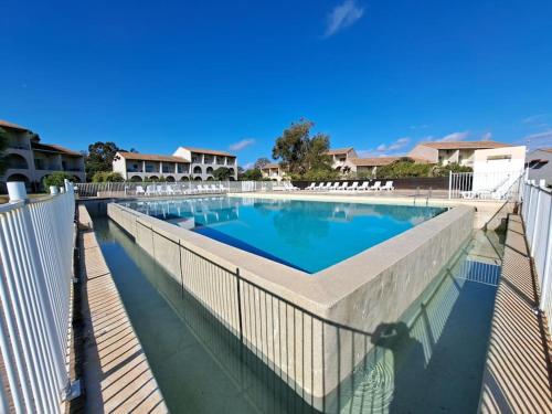 une grande piscine entourée d'une clôture. dans l'établissement Appartement avec piscine à 2 pas de la plage, à Linguizzetta