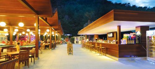 a restaurant with a bar and tables and chairs at Julian Forest Suites in Marmaris