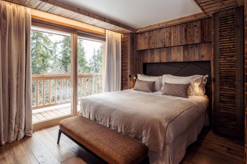 une chambre avec un lit et une grande fenêtre dans l'établissement Antarès URSA 101 - luxury apartment ski inski out, à Méribel