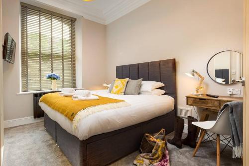 a bedroom with a large bed and a desk at No 1, Midland Bank Chambers in Ambleside