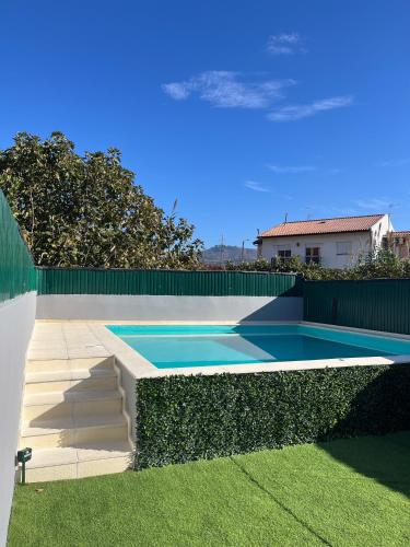 a swimming pool in a yard next to a fence at Casa do Carriço in Peso da Régua