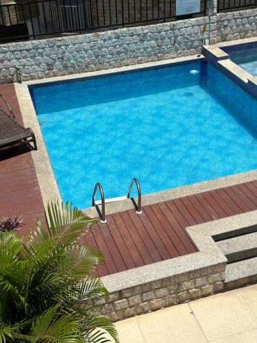 a large swimming pool with a brick walkway around it at Pousada Mariá in Cabo Frio