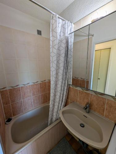 une salle de bain avec un lavabo, une baignoire et un miroir dans l'établissement Studio Confortable & Lumineux - Vue Montagne & Lac - Plan d'Eau, à Embrun