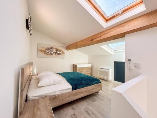 une chambre avec un lit et une lucarne dans l'établissement Duplex refait à neuf au cœur de Sanary, à Sanary-sur-Mer