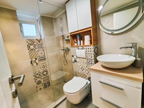 a bathroom with a toilet and a sink and a mirror at Teka’s home in Sarajevo