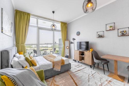 a bedroom with a bed and a desk and a tv at Elegant Studio in Damac Hills - Exclusive Living with Premium Amenities, Managed by Think Realty in Dubai