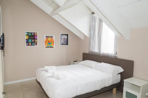 ローにあるAppartamenti Leonardoのベッドルーム1室(白いベッド1台付)