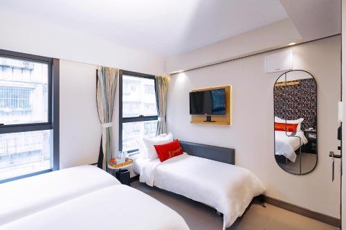a hotel room with two beds and a mirror at Belive&More in Macau