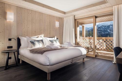a bedroom with a large bed and a large window at Antarès SIRIUS 503 - Spacious ski inski out apartment in Méribel