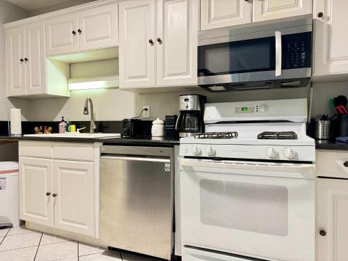 a kitchen with white cabinets and a stove and a microwave at Atlanta Downtown! High Rise! Onsite Parking LM609 in Atlanta