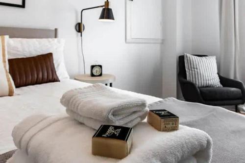 a bedroom with a bed with two books and a chair at Cute 1Bed Loft at The Foundry - Steps to Riverside in Cleveland