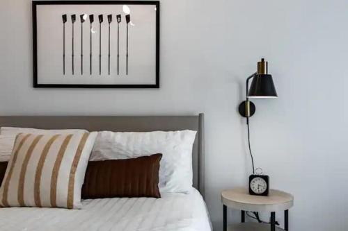 a bedroom with a bed and a table with a clock at Cute 1Bed Loft at The Foundry - Steps to Riverside in Cleveland
