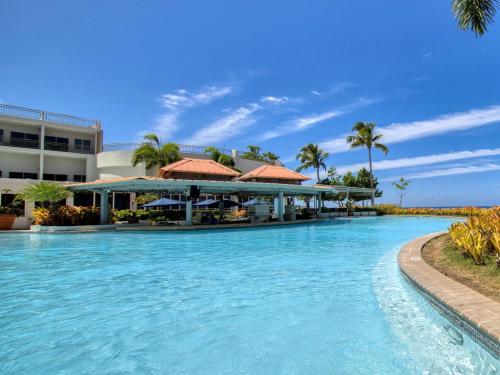 a pool at a resort with palm trees at Rincon of the Seas Grand Caribbean Hotel in Rincon