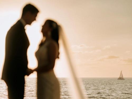 a bride and groom kissing in front of the ocean at Rincon of the Seas Grand Caribbean Hotel in Rincon