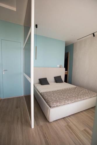 a bedroom with a white bed and a blue wall at Vila Luarasi Blue Apartment in Kaninë