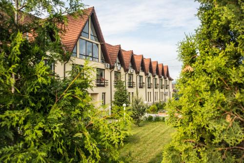 a row of houses with trees in the foreground at Conacul Archia in Deva