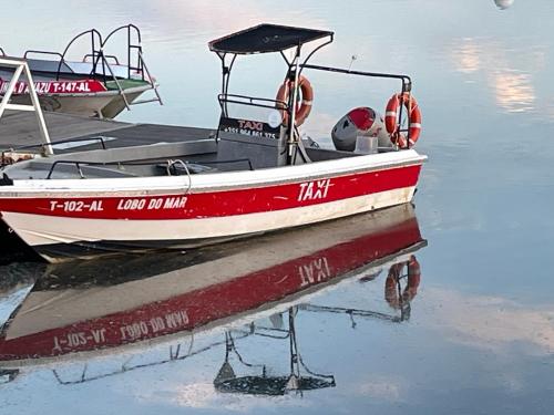 a red and white boat sitting on the water at Golden Club- Eyes on Sea in Cabanas de Tavira