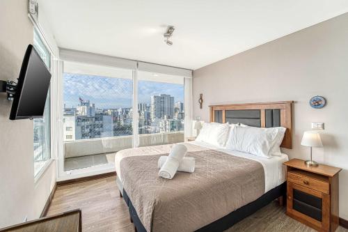 una camera da letto con un letto grande e una grande finestra di Costa Viña 3B Balcony & View a Viña del Mar