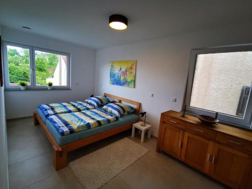 a bedroom with a bed and a dresser and a window at Ferienwohnung Kolpingstraße in Neuburg an der Donau