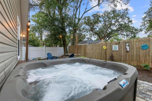 a hot tub in a backyard with a fence at Peaceful Pearl Retreat- 5 Minutes to Downtown, 10 Minutes to Beach in St. Augustine