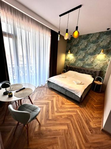 a bedroom with a bed and a table and chairs at MK Apart Boutique 2 in Voluntari