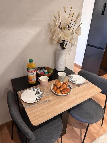 une table en bois avec une assiette de nourriture dessus dans l'établissement L'Elégant Charmant appartement centre historique, à Bergerac