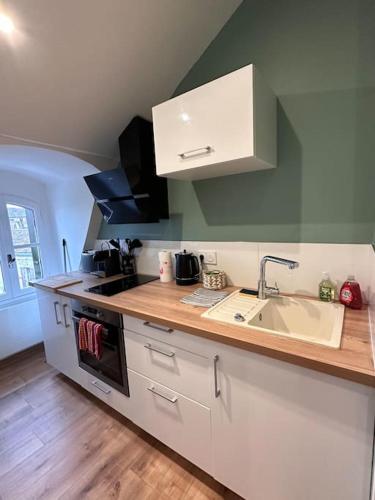 une cuisine avec un évier et un plan de travail dans l'établissement L'Elégant Charmant appartement centre historique, à Bergerac