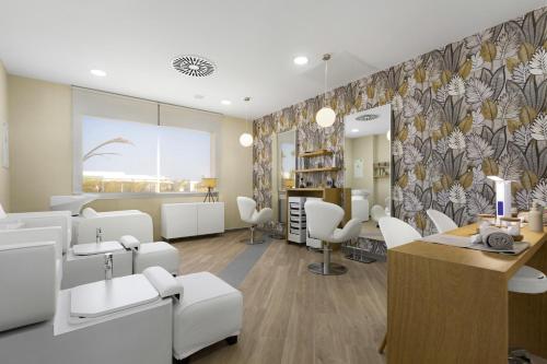 a salon with a waiting room with white chairs at Hotel Riu Palace Santa Maria - All Inclusive in Santa Maria