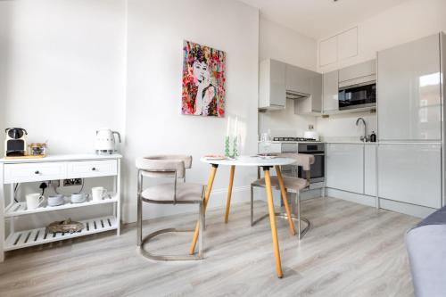 a kitchen with a table and chairs in a room at Hampstead High Flyer in London