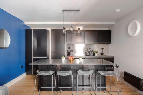 a kitchen with a bar with stools at Stylish 1-Bed Apartment near Seven Dials in London