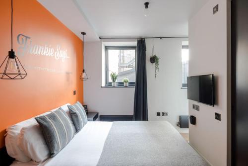 a bedroom with a bed with an orange wall at Stylish 1-Bed Apartment near Seven Dials in London