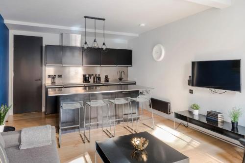 a kitchen with a bar and some chairs in a room at Chic 1-Bed Apartment near Covent Garden Piazza in London